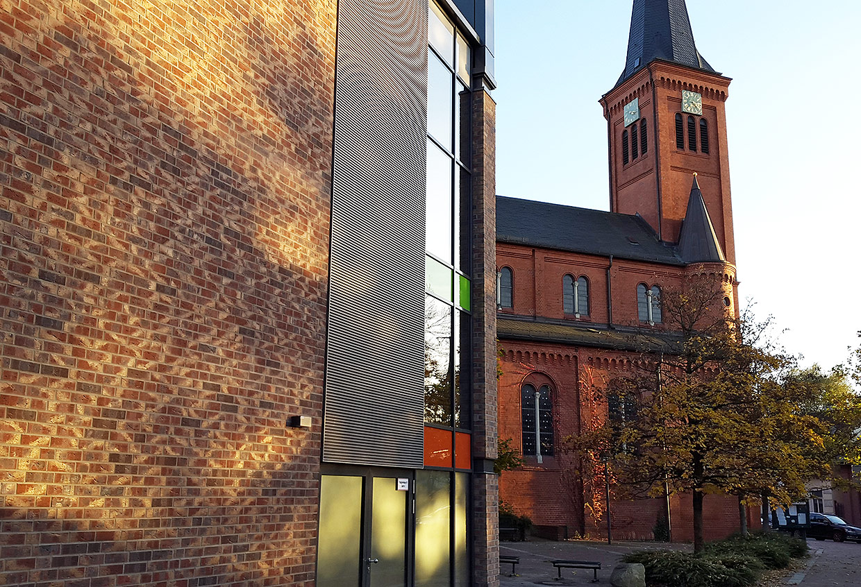 Fassadendetailansicht Holsten Galerie mit Ansicht Pfarrkirche St. Maria-St. Vicelin . Neubau Holsten Galerie, Neumünster