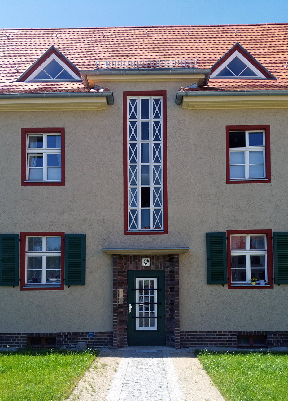 Außenansicht Mehrfamilienhaus, Detailansicht Fassade mit Eingangsbereich . Sanierung Eisenbahnersiedlung, Elstal/ Wustermark