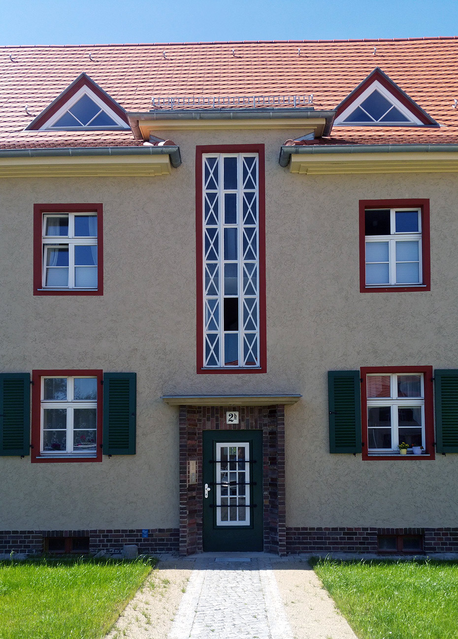 Außenansicht Mehrfamilienhaus, Detailansicht Fassade mit Eingangsbereich . Sanierung Eisenbahnersiedlung, Elstal/ Wustermark Außenansicht Mehrfamilienhaus, Detailansicht Fassade mit Eingangsbereich . Sanierung Eisenbahnersiedlung, Elstal/ Wustermark