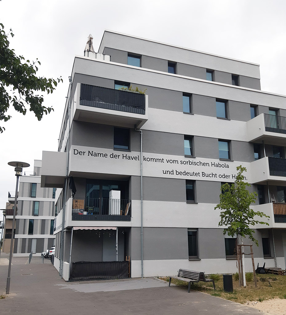 Ansicht Wohnhaus mit Namenserläuterung: Der Name der Havel kommt vom sorbischen Habola und bedeutet Bucht oder Hafen . Neubau Wasserstadt Oberhavel, Berlin-Spandau Ansicht Wohnhaus mit Namenserläuterung: Der Name der Havel kommt vom sorbischen Habola und bedeutet Bucht oder Hafen . Neubau Wasserstadt Oberhavel, Berlin-Spandau